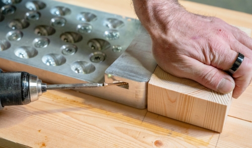 Pre-installing a fire-rated wood block to the bottom of an APEX beam hanger using the diagonal milled holes in its pocket